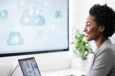 Jassika Chijuka reviewing cloud architecture on a large monitor in a bright workspace